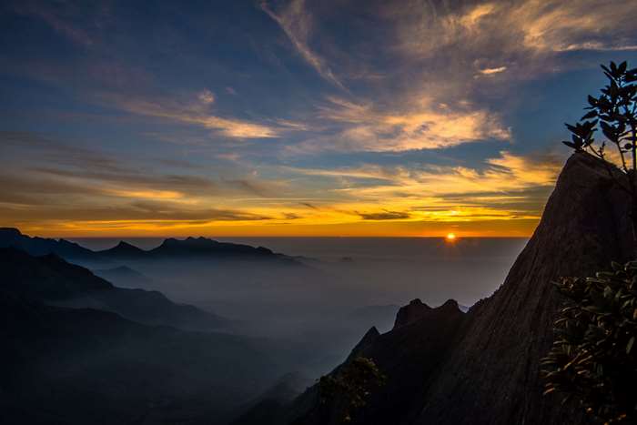 Sunrise over misty mountains with rocky foreground