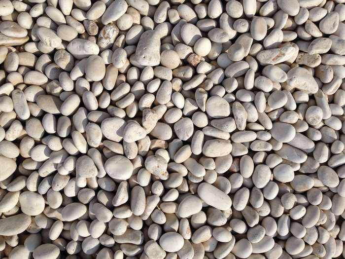 A pile of smooth, white pebbles on a beach