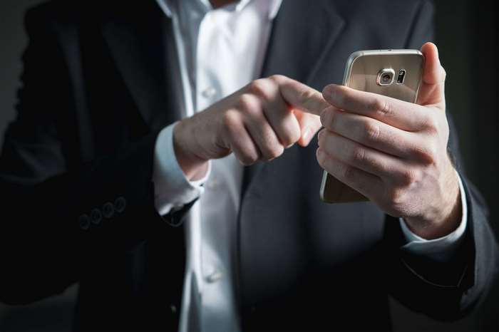Man in Suit Using Smartphone