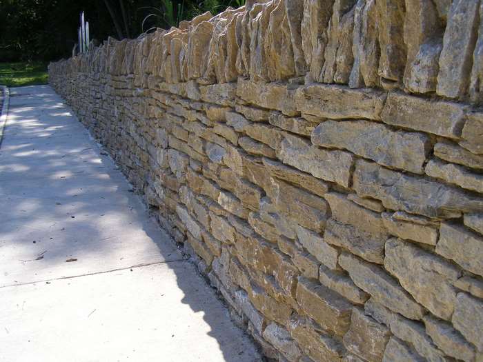 Stone wall along a concrete path