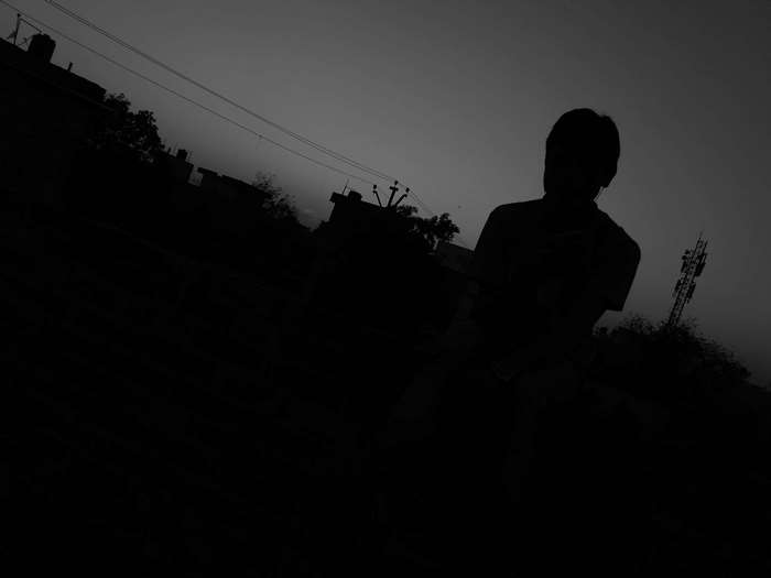 Silhouette of a person against the evening sky with radio tower