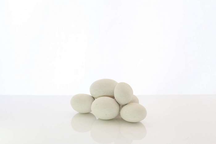 White pebbles stacked on a white surface