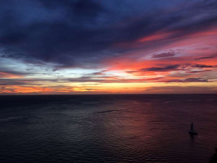 Sunset over the ocean with a sailboat in Phuket, Thailand 4K