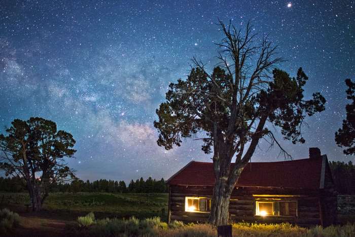 Log cabin under the Milky Way at night