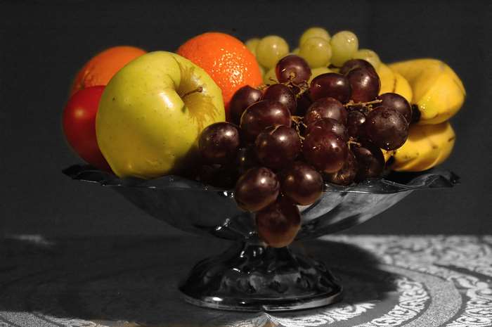 Still life fruit bowl with apples, bananas, oranges, and grapes