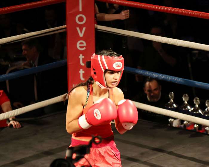 Girl boxing in a ring with trophies