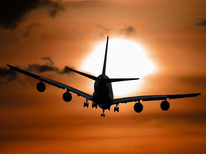 Airplane silhouette against a sunset sky