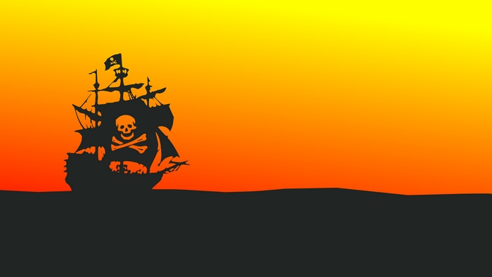 Pirate ship with Jolly Roger flag at sunset