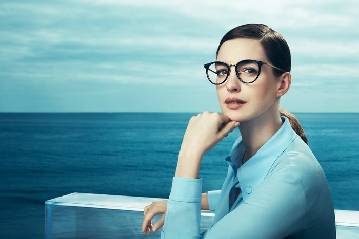 Anne Hathaway wearing glasses by the ocean
