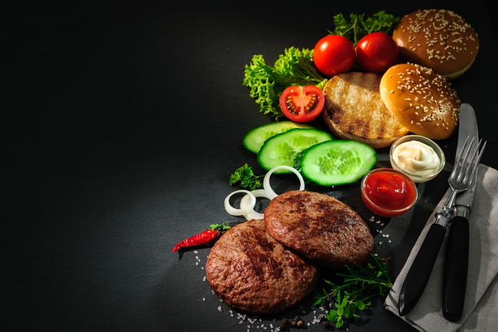 Burger ingredients with condiments and cutlery