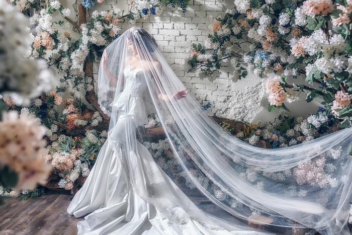 Bride in a white wedding dress with a veil and flowers