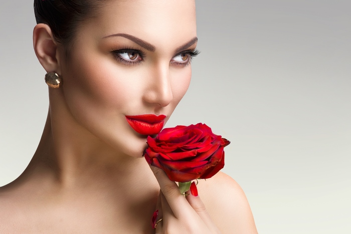 Woman with red lipstick holding a red rose