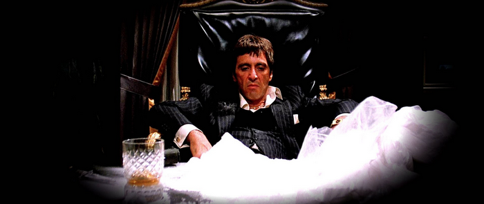 Tony Montana from Scarface sitting with cocaine