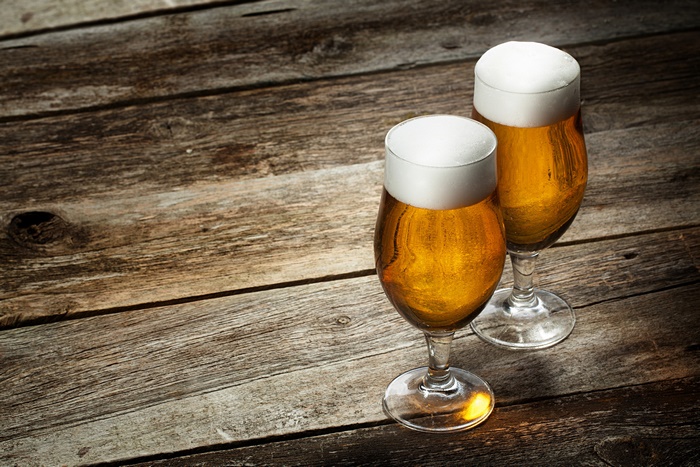 Two glasses of beer on a wooden table