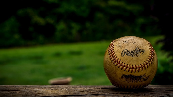 A Rawlings baseball on a wooden surface