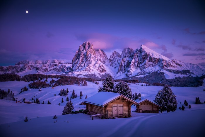 Winter mountain landscape with cabins and moon