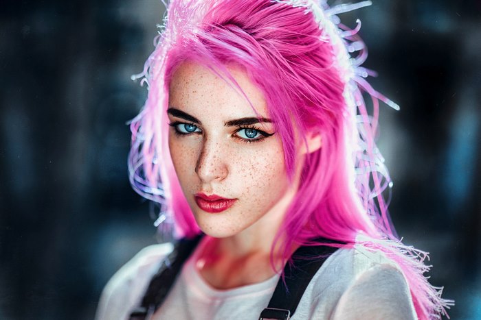 Woman with pink hair and blue eyes with freckles