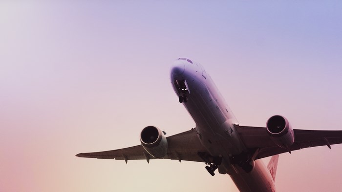 Airplane taking off against a colorful sky