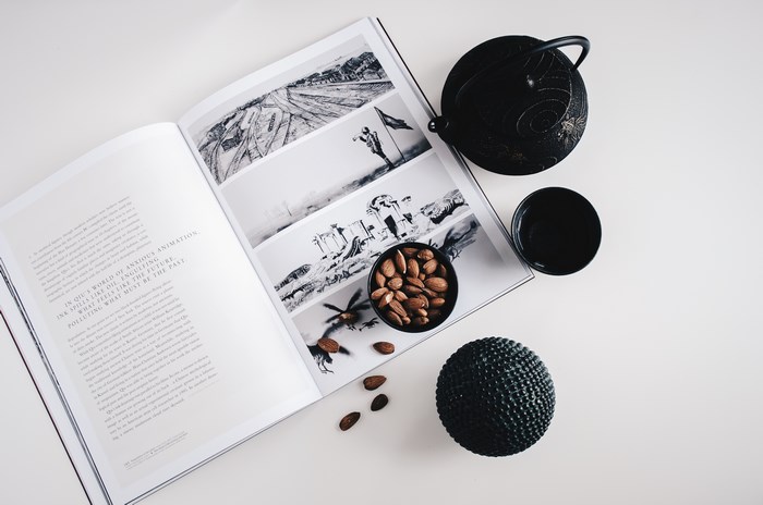 Flatlay of a magazine, teapot, tea cup, almonds, and decorative ball