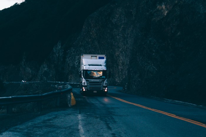 Truck driving on a mountain road at dusk