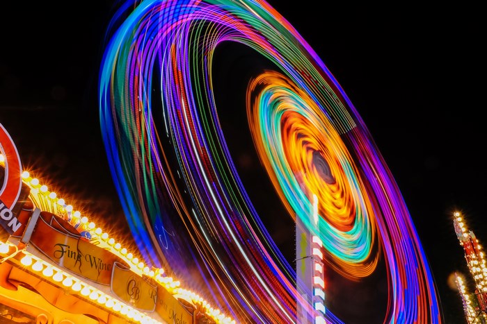 Spinning carnival ride with colorful lights at night