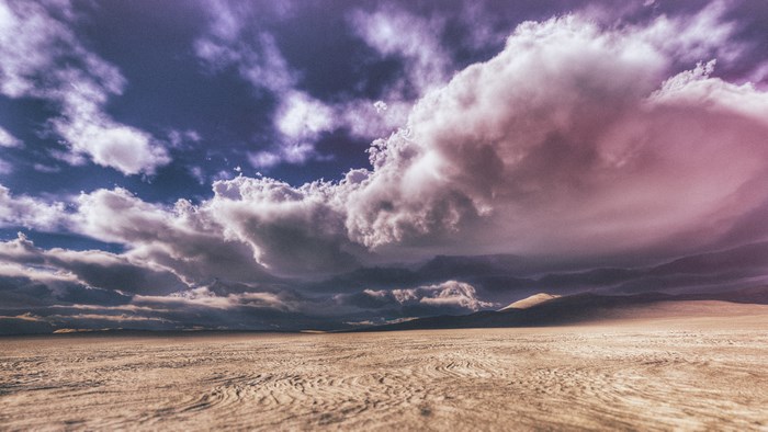 Dramatic clouds over a sandy desert landscape