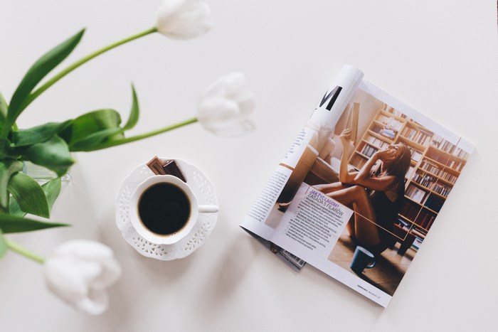 White tulips, coffee cup, and magazine on a table