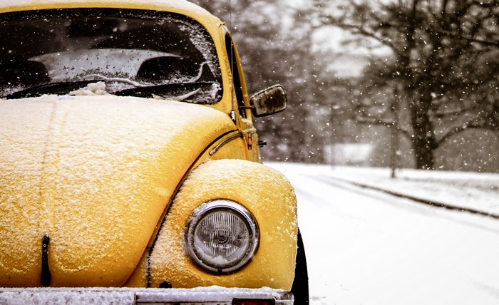 Yellow Volkswagen Beetle covered in snow