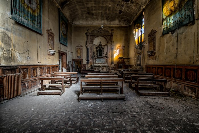 Abandoned church interior with pews and altar