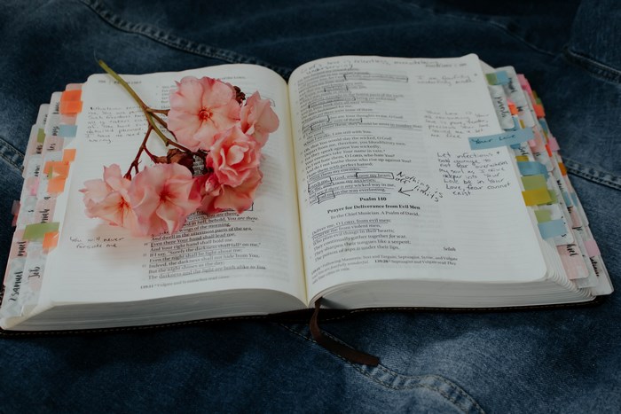 Open Bible with pink flowers and handwritten notes