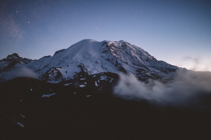 Snowy mountain peak under a starry night sky