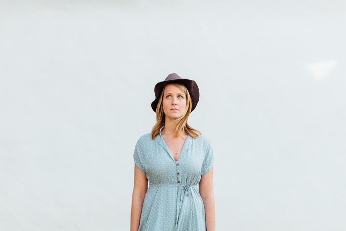 Woman in polka dot dress and hat looking up