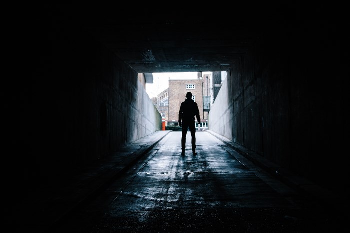 Man silhouetted in a dark tunnel