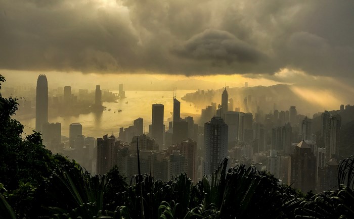 Hong Kong cityscape during a rainstorm with sunbeams