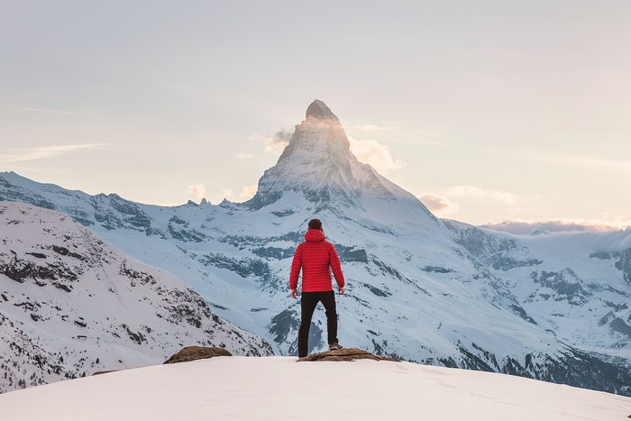Man in Red Coat Facing Snowy Zermatt Mountain Peak