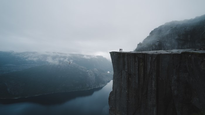 Couple on Misty Cliff Overlooking Norwegian Fjord