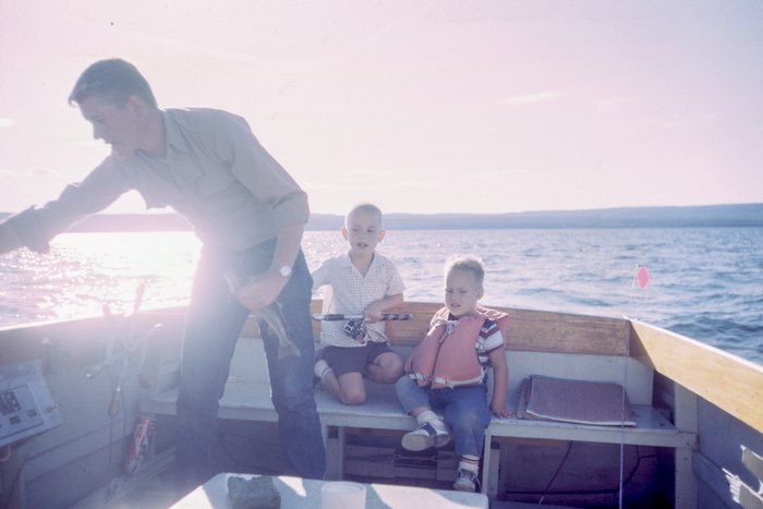 Father and sons fishing on a boat