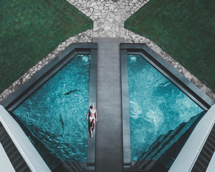 Woman sunbathing by pool with shark