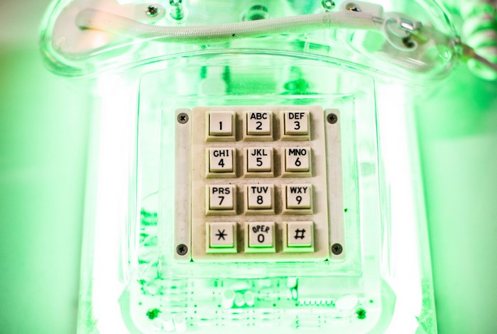 Transparent vintage telephone with green glow