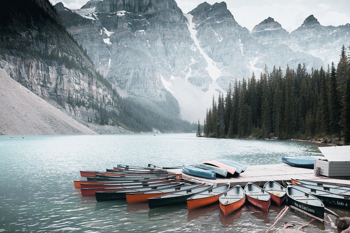 Canoes docked on Moraine Lake with mountains in background