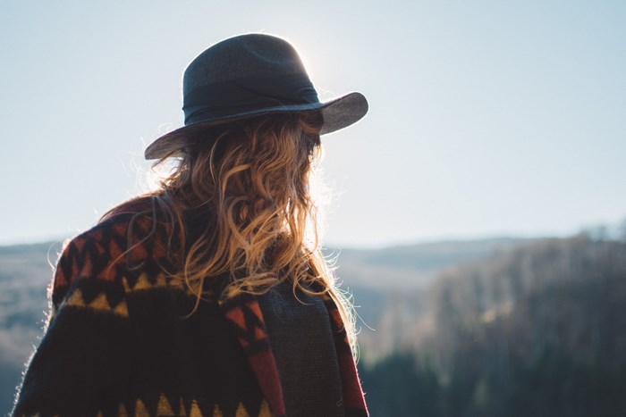 Woman in hat and poncho looking at landscape