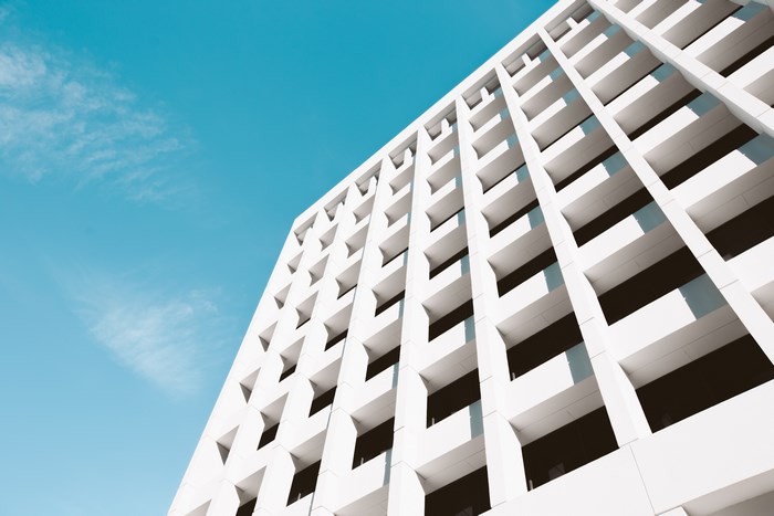 Minimalist white building facade against a blue sky