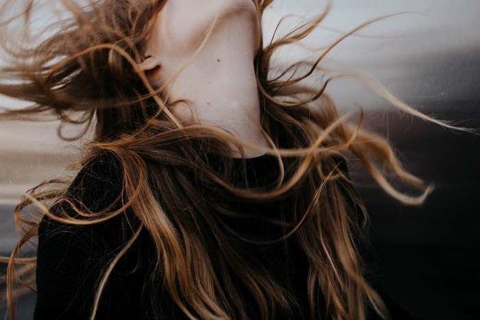 Woman with long brown hair blowing in the wind