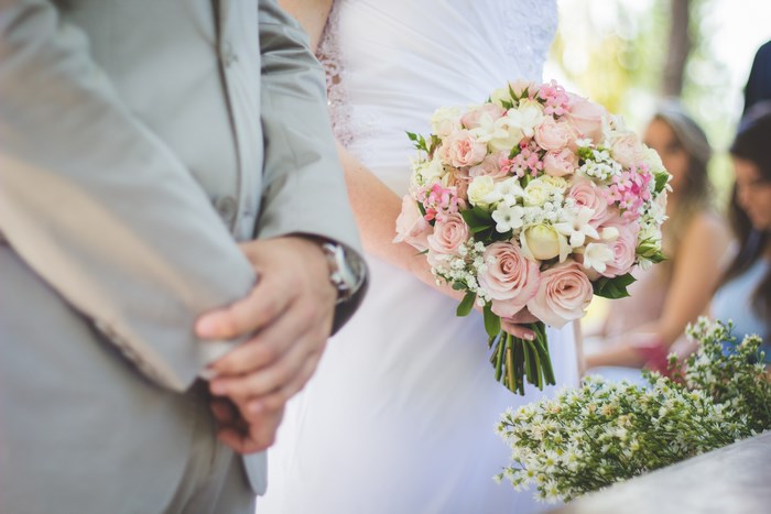 Bride holding a pink and white bouquet at a wedding