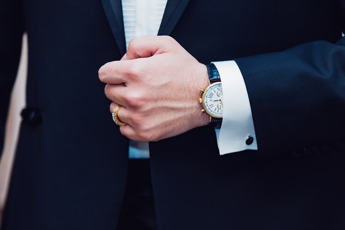 Man in suit wearing a watch and rings
