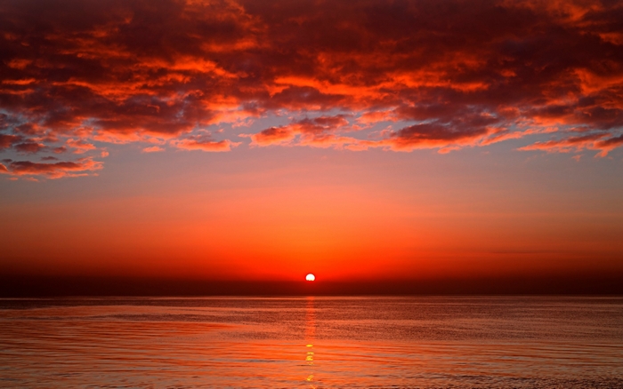 Sunset over the ocean with red clouds