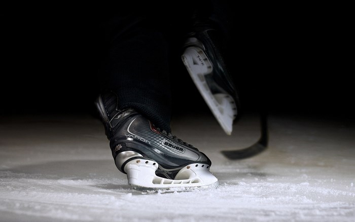 Hockey player skating on ice with stick