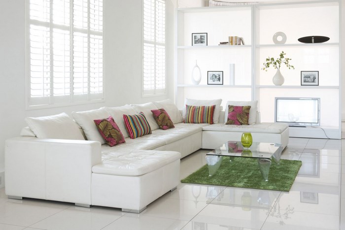 Modern living room with white sectional sofa and glass coffee table