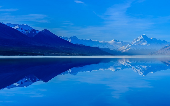 Snow-capped mountains reflected in a calm lake