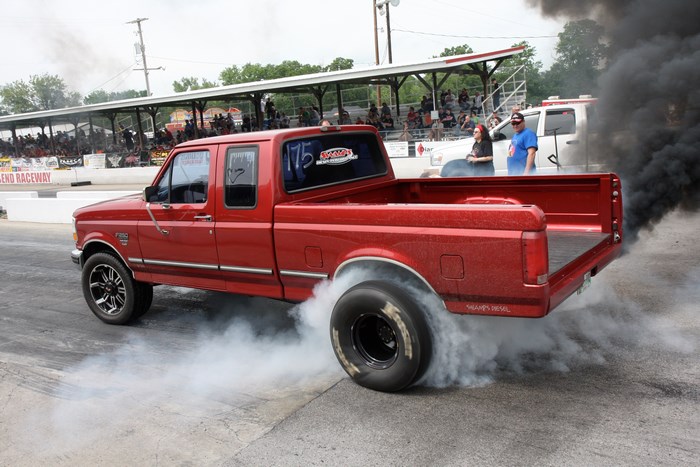 Red Ford F-250 Super Duty truck doing a burnout